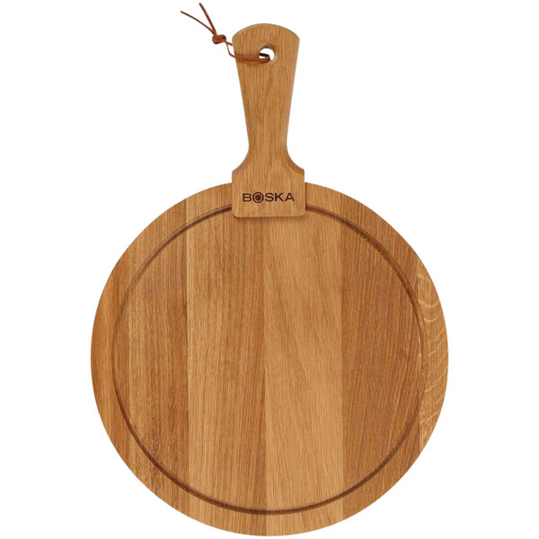 A Boska medium round oak serving board with a handle.