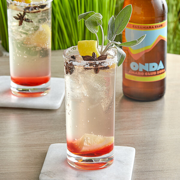 Two glasses of Casamara Club Onda Wild Limonata soda with a lemon slice on a table