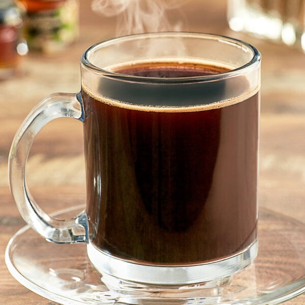 A glass mug filled with Ellis Hazelnutty coffee with steam coming out of it.