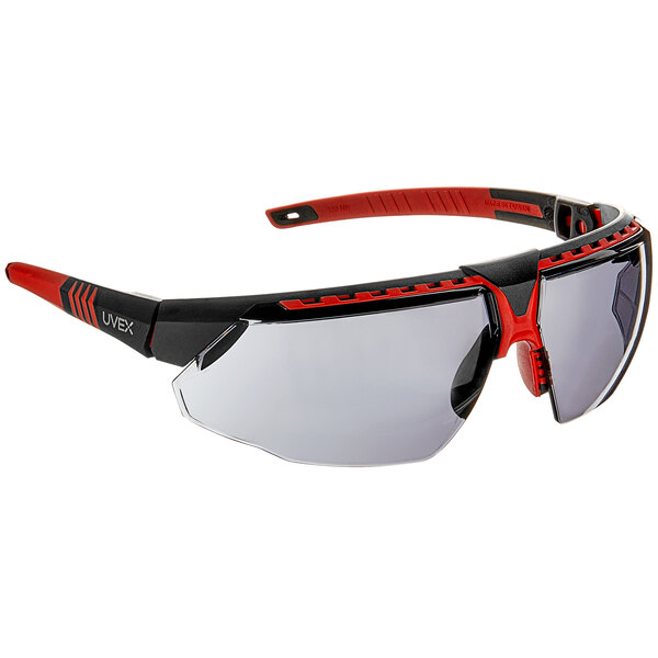A pair of Honeywell safety glasses with red frames and gray lenses.