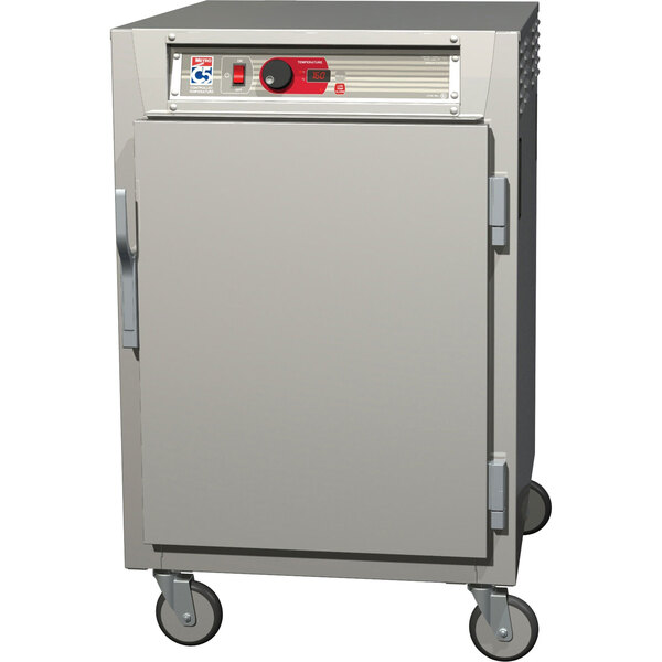 A stainless steel Metro heated holding cabinet with wheels and a solid door.