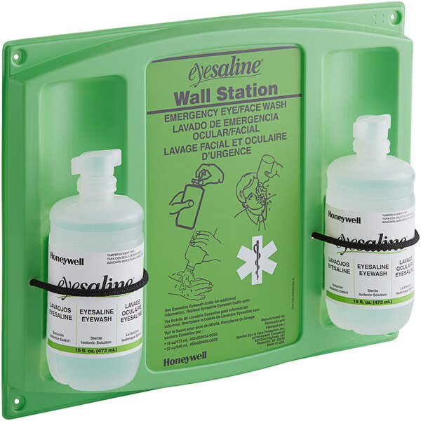 A green wall station with two bottles of eye wash.