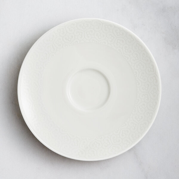 A white RAK Porcelain flat plate with an embossed pattern on the rim.