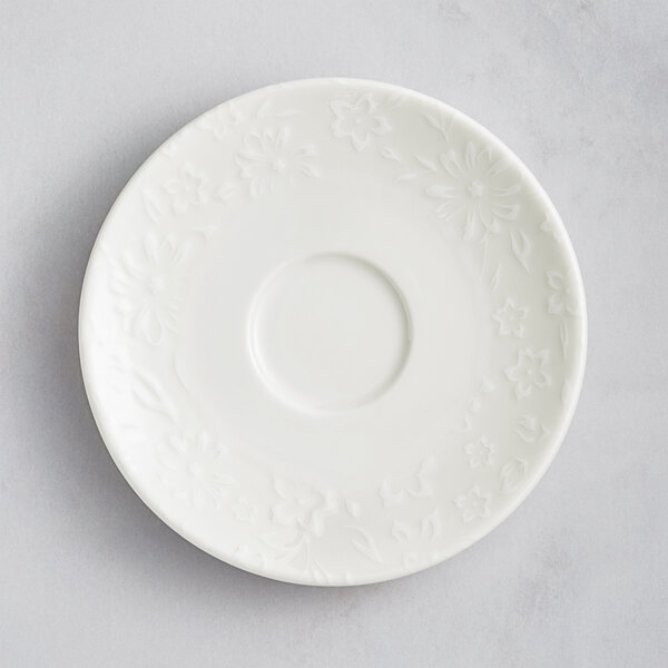 A white porcelain saucer with flowers on it.
