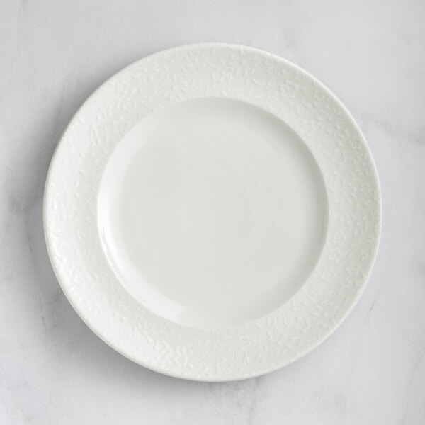 A RAK Porcelain ivory flat plate with an embossed circular edge.