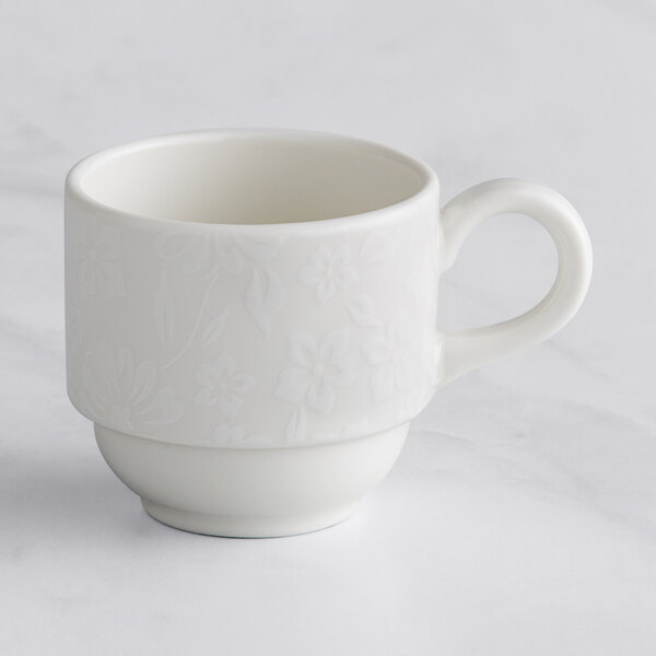 A white RAK Porcelain espresso cup with an embossed floral design.