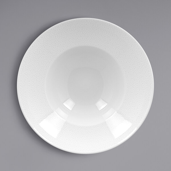 A white porcelain plate with an ivory rim with an embossed pattern.
