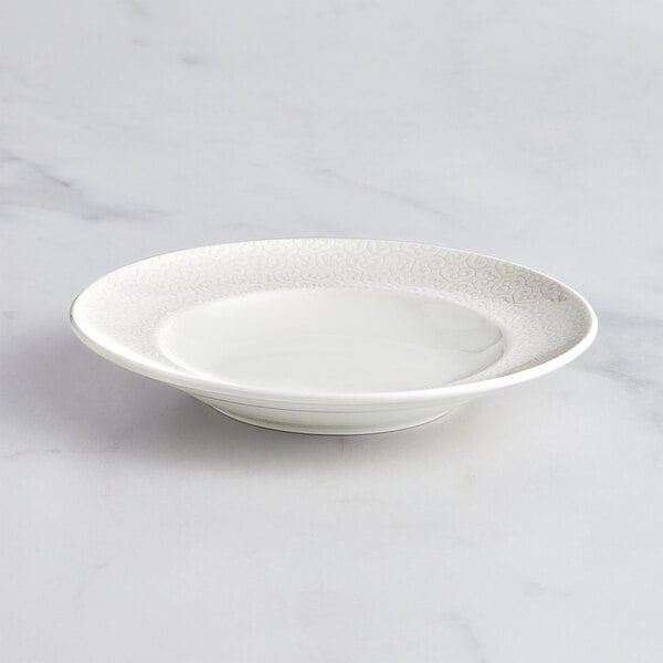 A RAK Porcelain ivory porcelain deep plate with an embossed rim.
