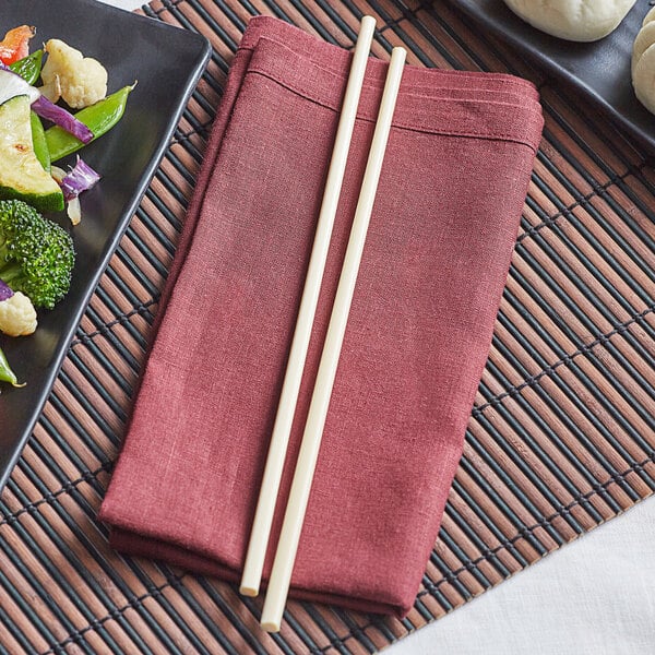 A plate of vegetables with Emperor's Select ivory melamine chopsticks on a table.