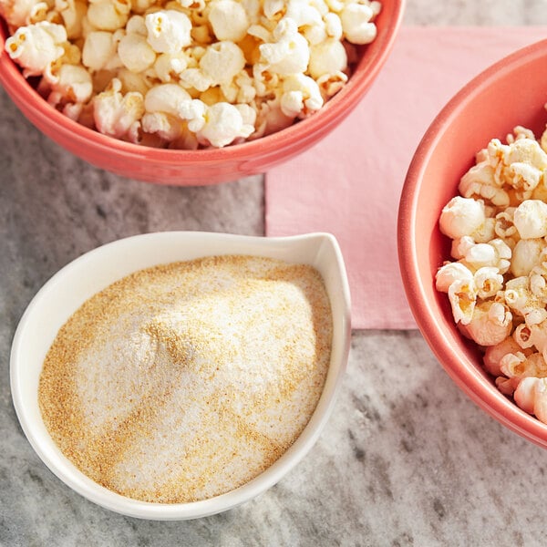 A bowl of popcorn with white and yellow powder on top.