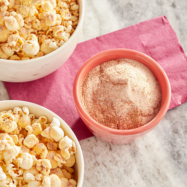 A bowl of popcorn with Carnival King Spicy Cayenne Popcorn Seasoning powder.