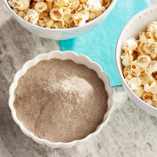 A bowl of popcorn with Carnival King Salt and Pepper Popcorn Seasoning powder.