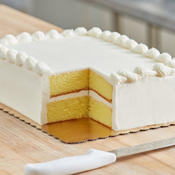 A cake with a slice missing on a gold laminated corrugated cake board.