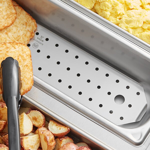 A metal tray with food in it with a Vigor stainless steel false bottom inside.