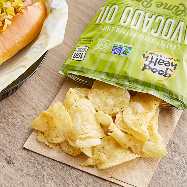 A hot dog and Good Health Avocado Oil Lime Ranch Kettle Chips on a table.