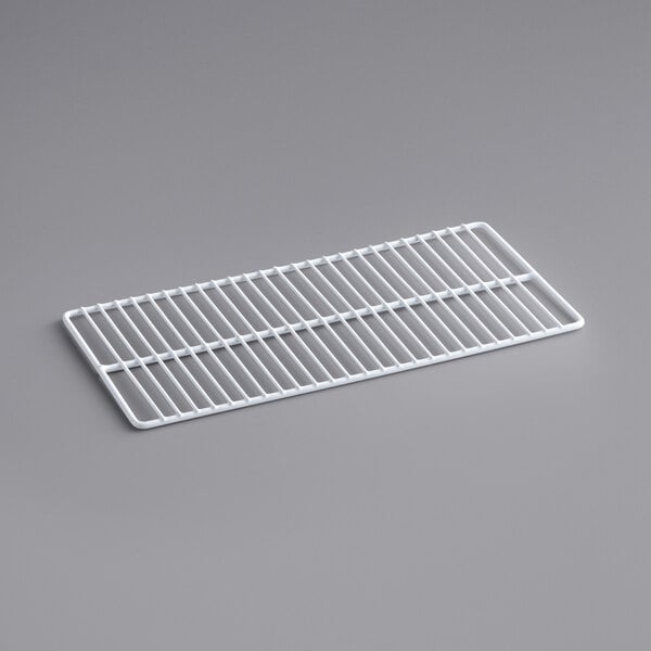A white coated wire shelf for a refrigerated merchandiser on a gray surface.