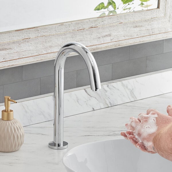 A person washing their hands with soap under a Waterloo hands-free faucet.