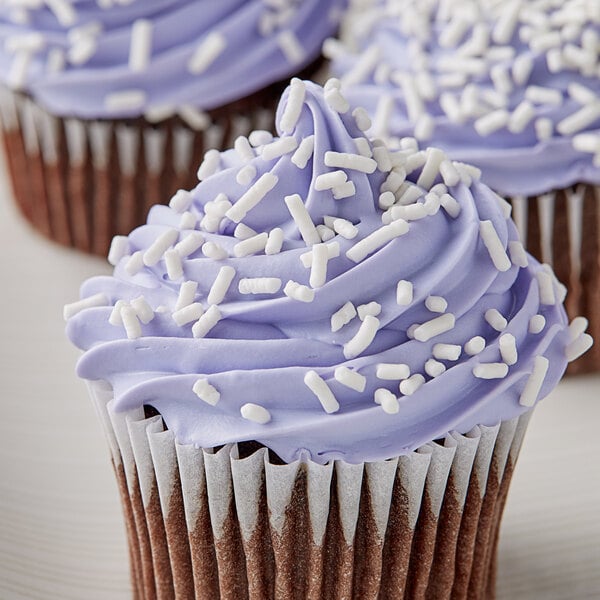 A close-up of a cupcake with purple frosting and Bake-Stable White Sprinkles.