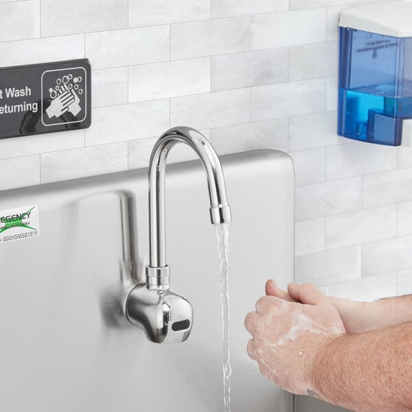A person washing their hands under a Waterloo wall mount hands-free sensor faucet.