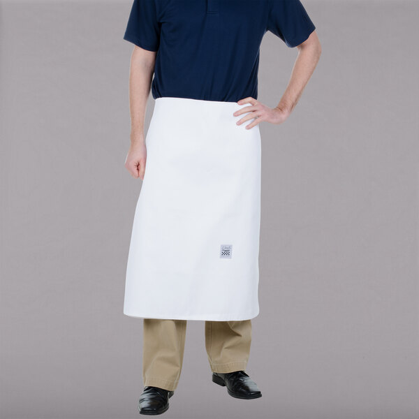 A man wearing a white Chef Revival bistro apron with his hands on his hips.