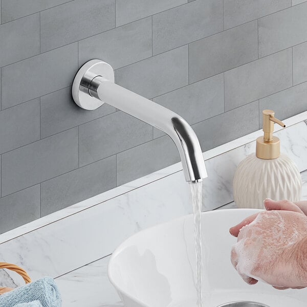 A person washing their hands under a Waterloo wall-mounted hands-free sensor faucet.