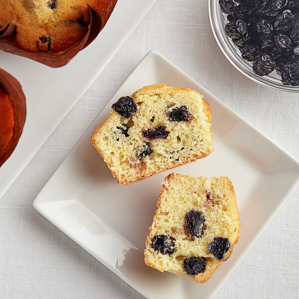 A plate with muffins topped with Dried Blueberries.