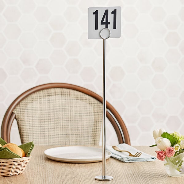 A Tablecraft chrome-plated menu / card holder with a table number on it.