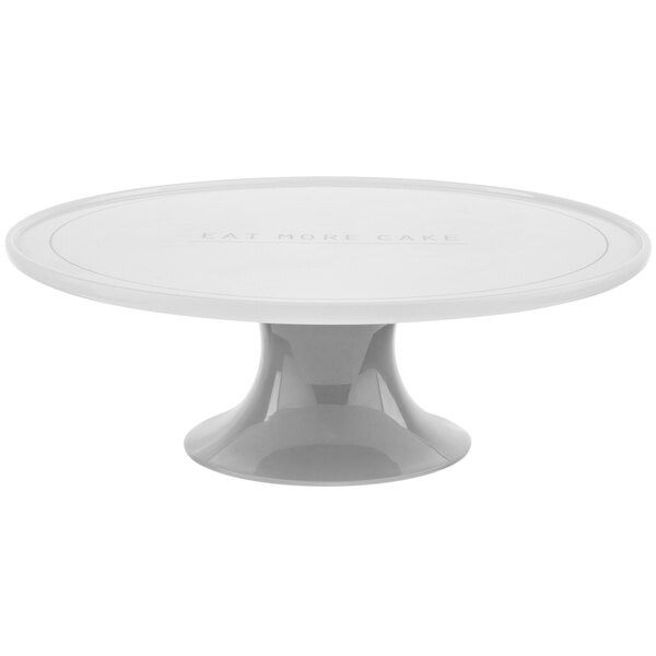 A white Tablecraft cake stand with "Eat More Cake" text on the surface.