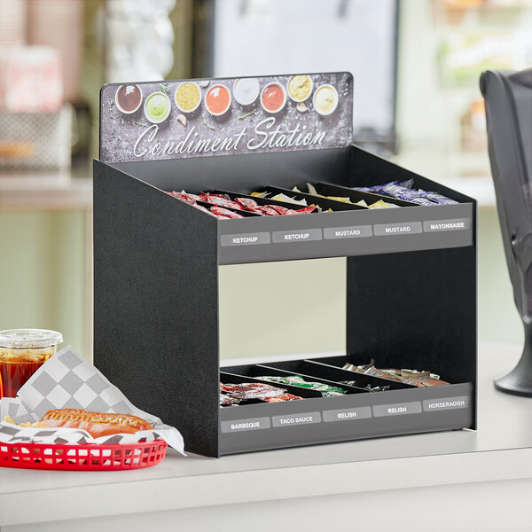 A ServSense black condiment organizer with a sign and removable dividers on a counter.