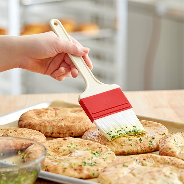 A hand holding a Choice pastry brush over food.