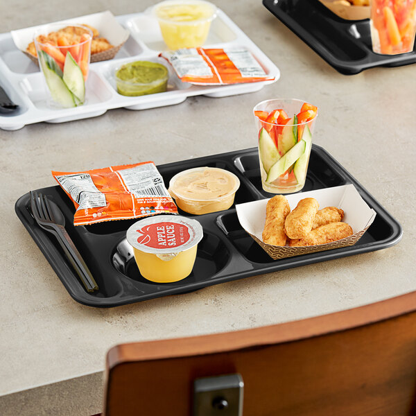 A left-handed black Choice compartment tray with food, a spoon, and a cup on a table.