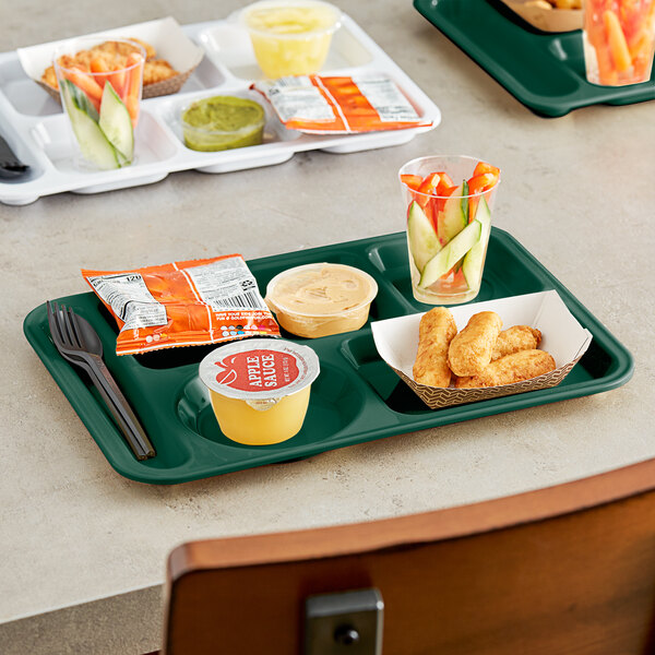 A forest green Choice left handed compartment tray with food, a spoon, and a fork.