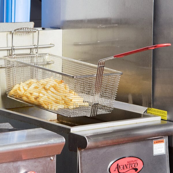 A Grindmaster-Cecilware fryer basket with french fries in it.
