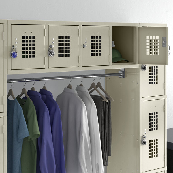 A Regency beige wall mount locker with clothes hanging inside.