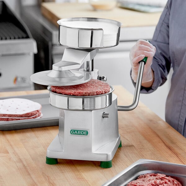 A person using a Garde heavy-duty hamburger patty press to make a meat patty.