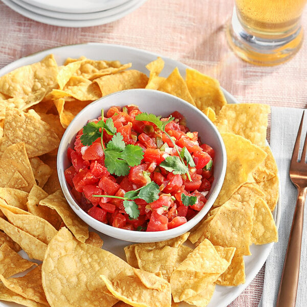 A plate of chips and salsa with a bowl of Red Gold Petite Diced Tomatoes & Green Chiles.
