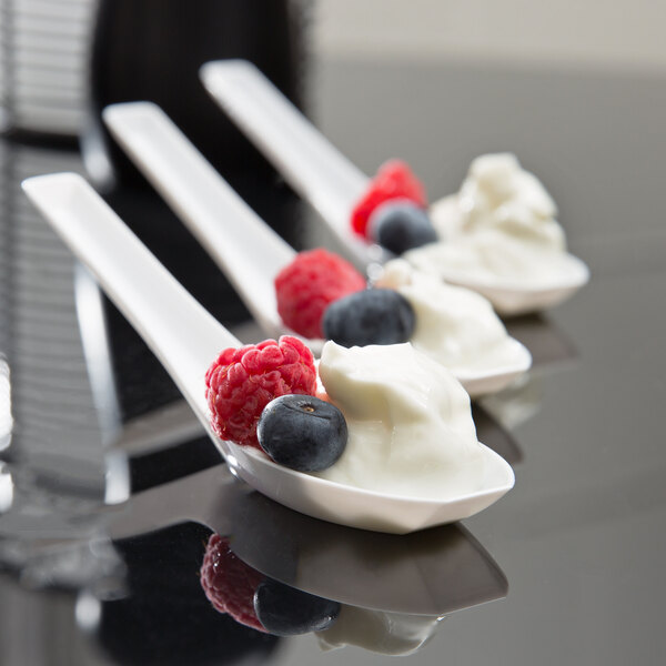 Three WNA Comet white Asian soup spoons with berries and cream on them.