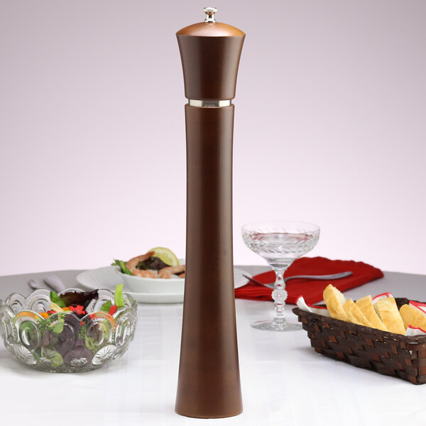 A Chef Specialties Pueblo pepper mill on a table with a plate of food.