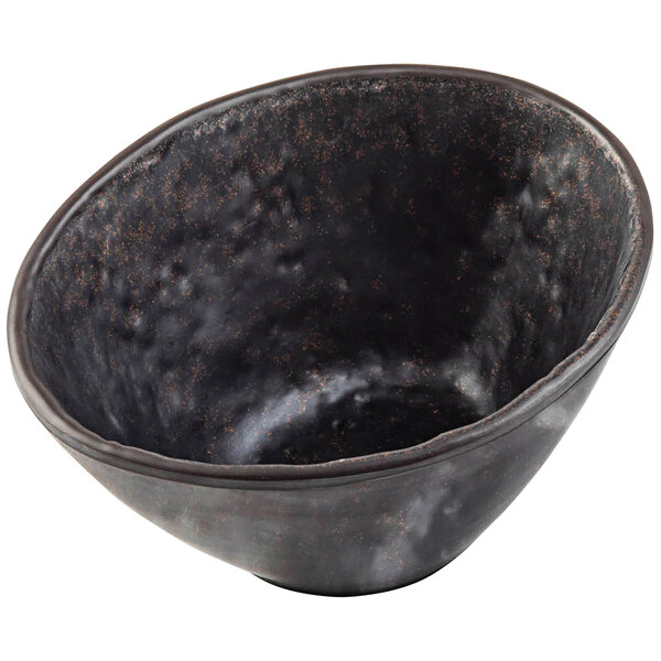 A black melamine sauce cup with brown specks.