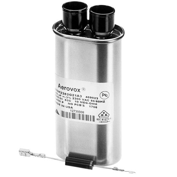 A silver Solwave capacitor with black and white wire caps.