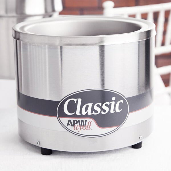 An APW Wyott stainless steel round food warmer with a lid.