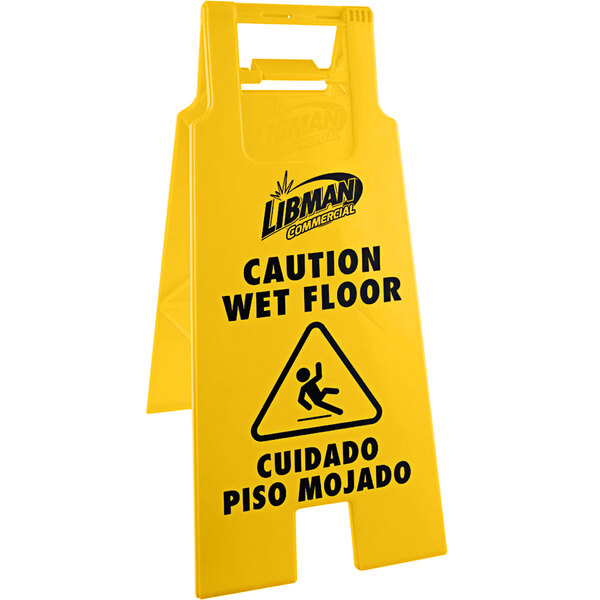 A yellow Libman wet floor sign with black text that reads "Caution Wet Floor"