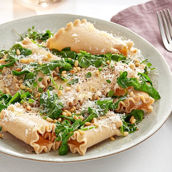 A plate of Barilla wavy lasagna noodles with spinach and parmesan cheese.