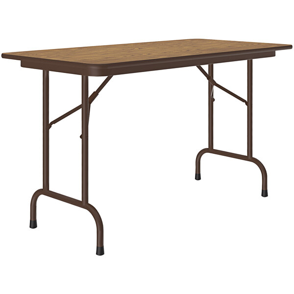 A rectangular Correll folding table with a medium oak top and brown frame.