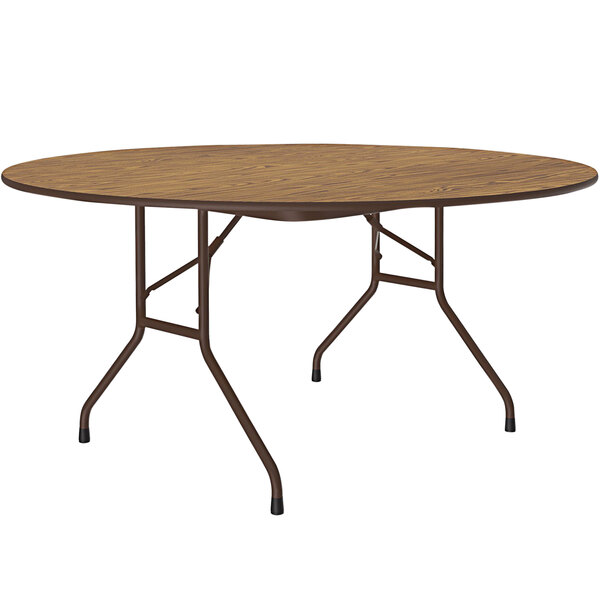 A Correll round folding table with a medium oak surface and brown frame.
