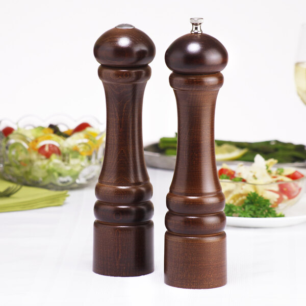 Two Chef Specialties Imperial Walnut pepper mills on a table.
