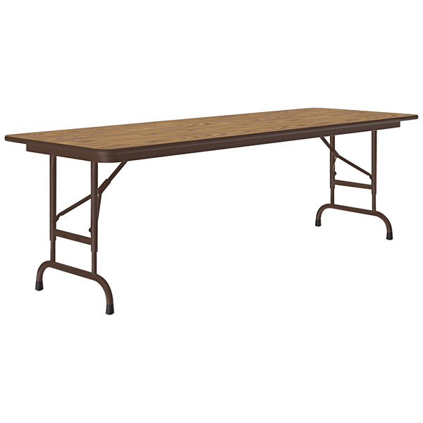 A rectangular Correll folding table with a medium oak wooden top and metal frame.