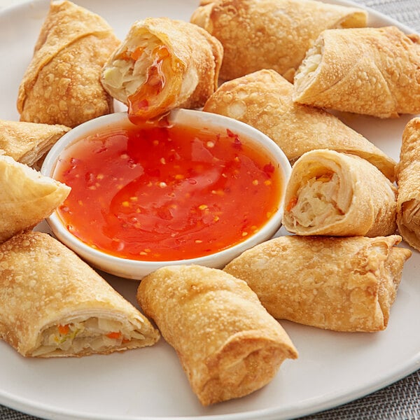 A plate of fried spring rolls with Sauce Craft Sweet Chili Sauce.