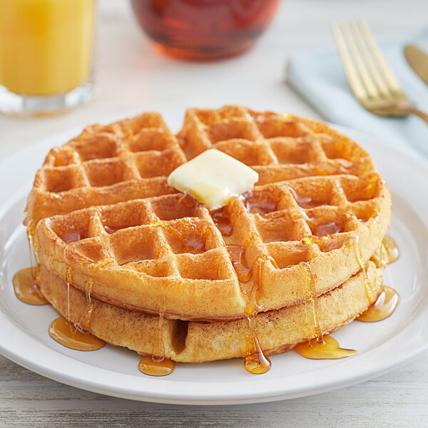 A white plate with Golden Dipt Belgian Waffles topped with butter and syrup.