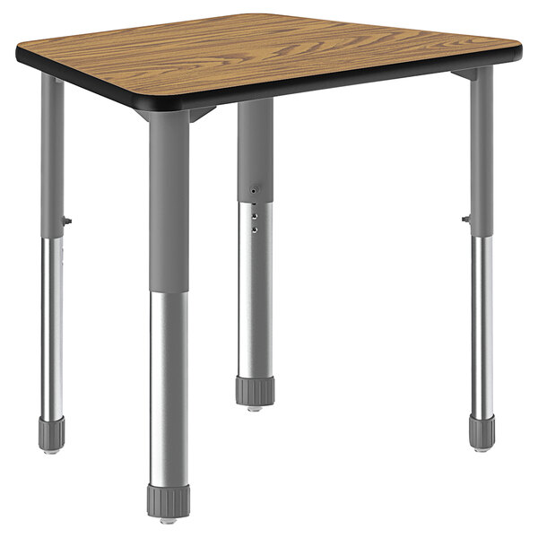 A trapezoid-shaped table with oak legs and a black metal base.